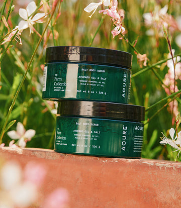 Sugar and Salt body scrub stacked in a natural green background with flowers