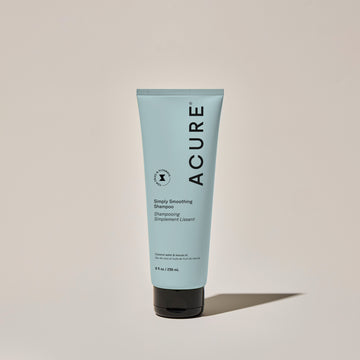 A tube of ACURE Simply Smoothing Shampoo against a neutral background.