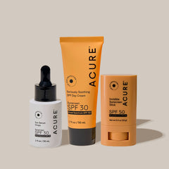 Three Acure sunscreen products on a beige background